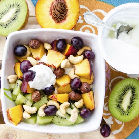 Cottage cheese with fruit and nuts and halves kiwi and peach. Concept of healthy eating for breakfast