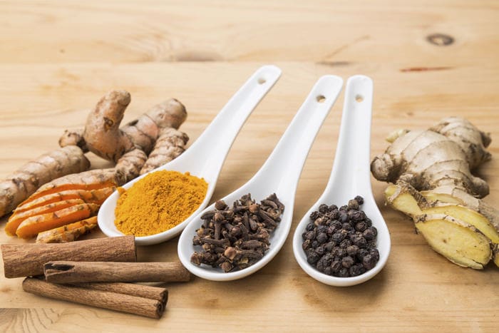 Ingredients for healthy turmeric tea consisting ginger, cinnamon, cloves and black pepper